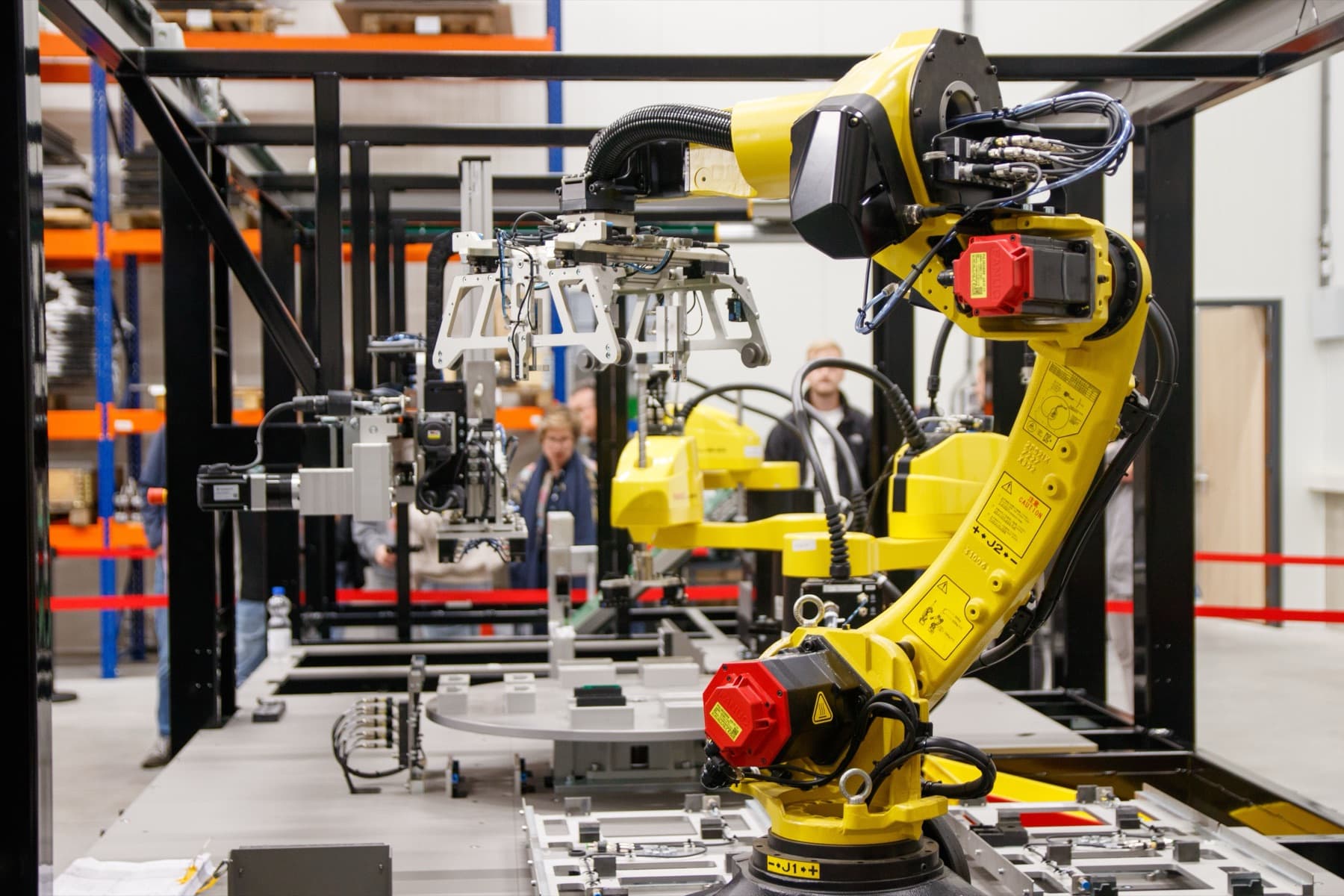 A yellow industrial robot arm on a factory line